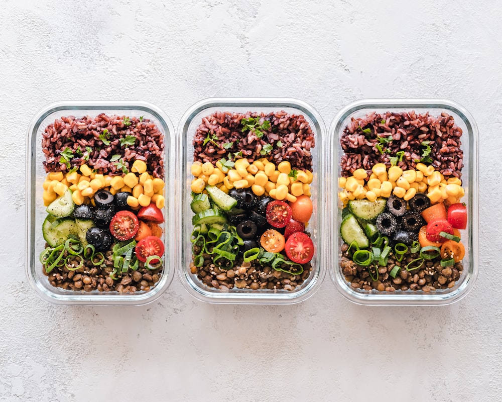 Organized meal prep containers with fresh vegetables and prepared dishes